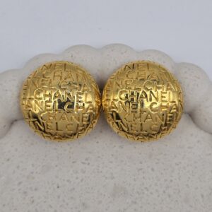CHANEL - złote okrągłe klipsy vintahe z tłoczonym logo widok z przodu