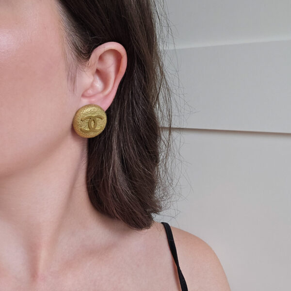 CHANEL - złote klipsy vintage z logo CC na modelce