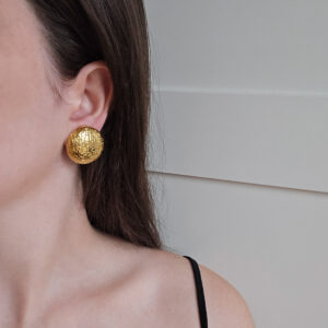 CHANEL - złote okrągłe klipsy vintahe z tłoczonym logo na modelce