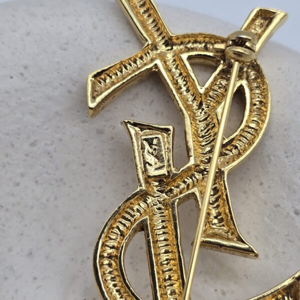 YSL - złota broszka vintage z monogramem zbliżenie na sygnaturę