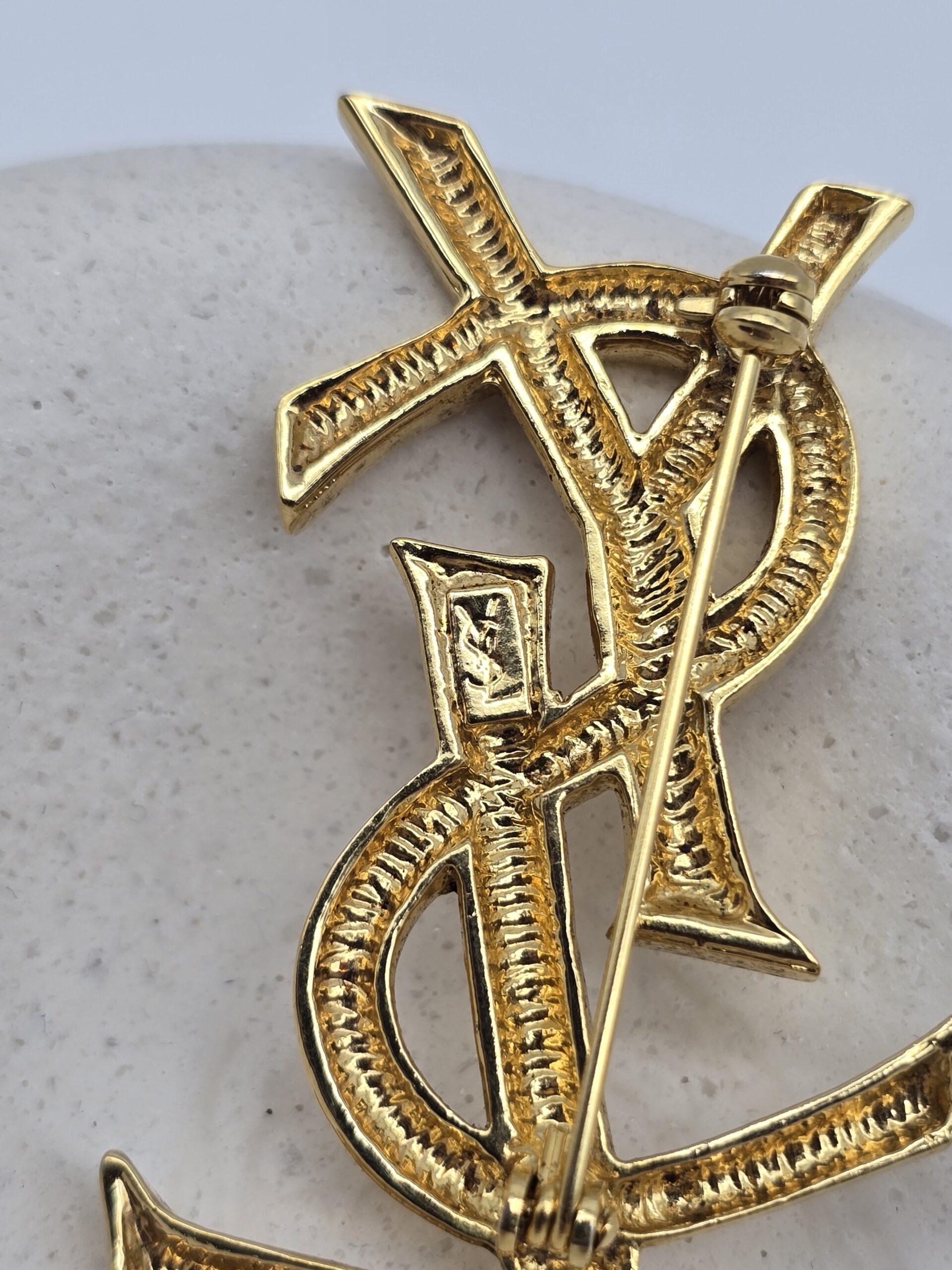 YSL - złota broszka vintage z monogramem zbliżenie na sygnaturę
