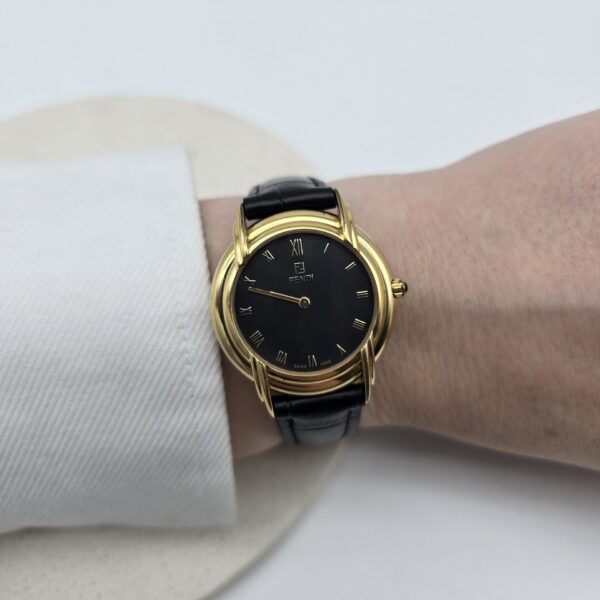 FENDI - złoty zegarek vintage z czarną tarczą na ręce