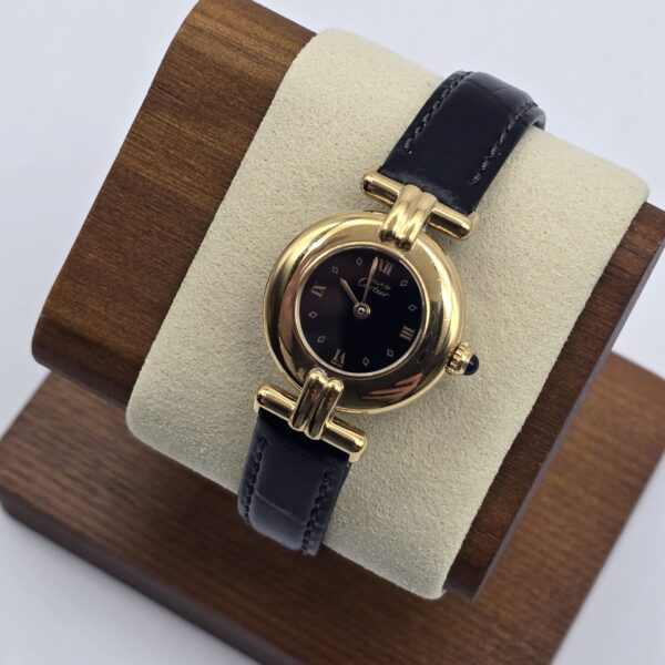 CARTIER - złoty zegarek vintage z ciemną tarczą na ekspozytorze