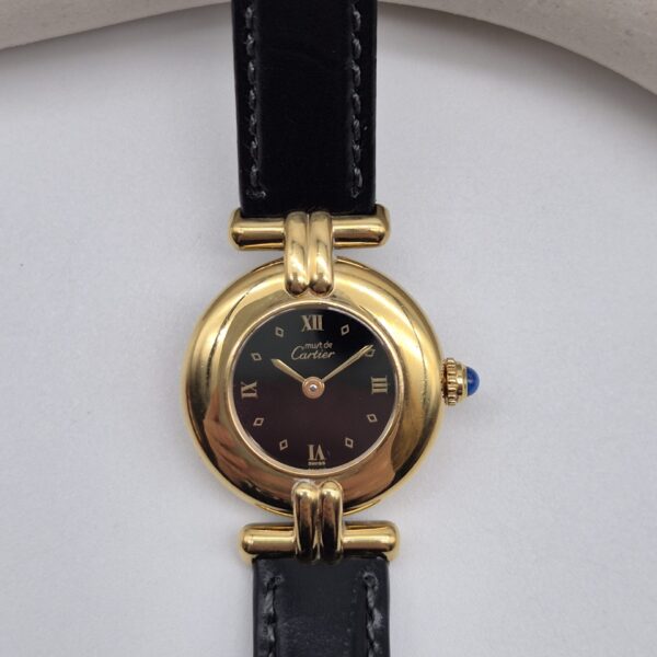 CARTIER - złoty zegarek vintage z ciemną tarczą zbliżenie na kopertę