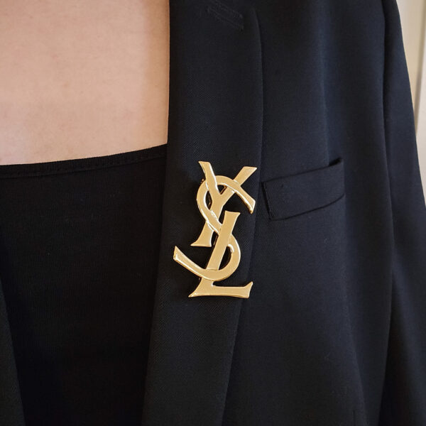 YSL - złota broszka vintage z monogramem na marynarce