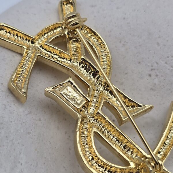 YSL - kultowa złota broszka vintage z monogramem zbliżenie na tył