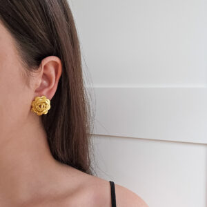 CHANEL - złote klipsy vintage w kształcie kamelii na modelce