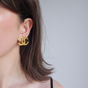 CHANEL - złote klipsy vintage CC fakturowane na modelce