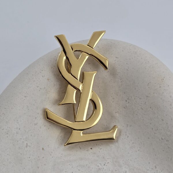 YSL - kultowa złota broszka vintage z monogramem