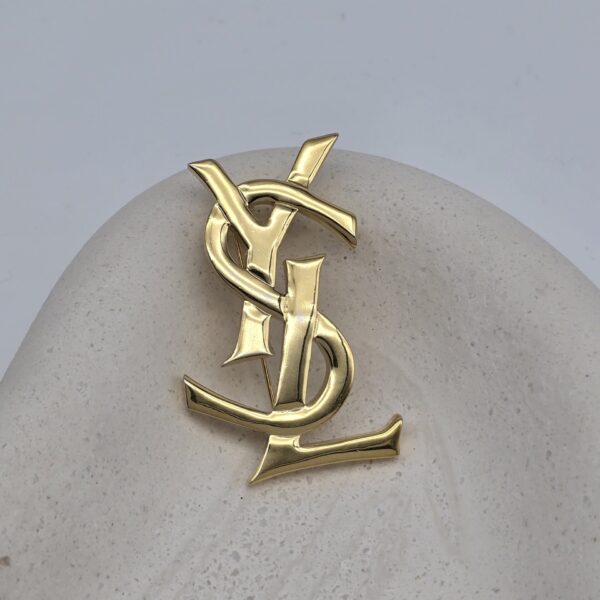 YSL - złota broszka vintage z monogramem