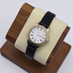 YSL - klasyczny złoty zegarek vintage na czarnym pasku na ekspozytorze