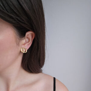 CHRISTIAN DIOR - delikatne złote klipsy z monogramem CD na modelce