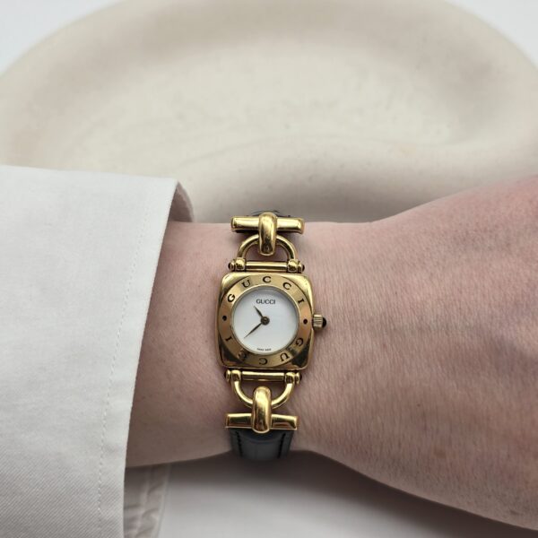 GUCCI - złoty zegarek vintage z jasną tarczą na ręce