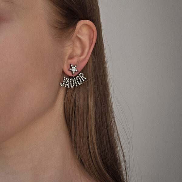 DIOR – asymetryczne kolczyki J’Adior na sylwetce logo