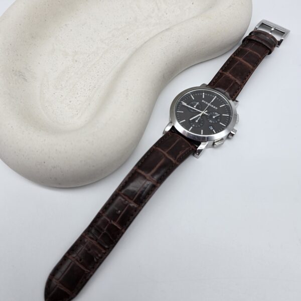 BURBERRY - zegarek z chronografem obok podkładki