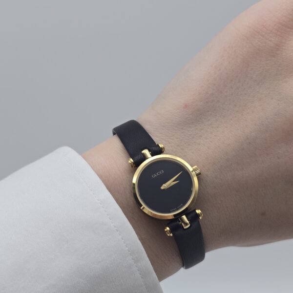 GUCCI - minimalistyczny zegarek vintage z czarną tarczą na ręku