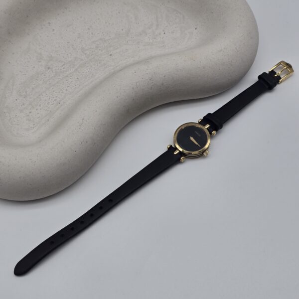 GUCCI - minimalistyczny zegarek vintage z czarną tarczą przy podstawce