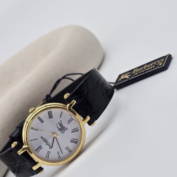BURBERRY - złoty zegarek vintage z rzymskimi indeksami, lata 90. przy podstawce