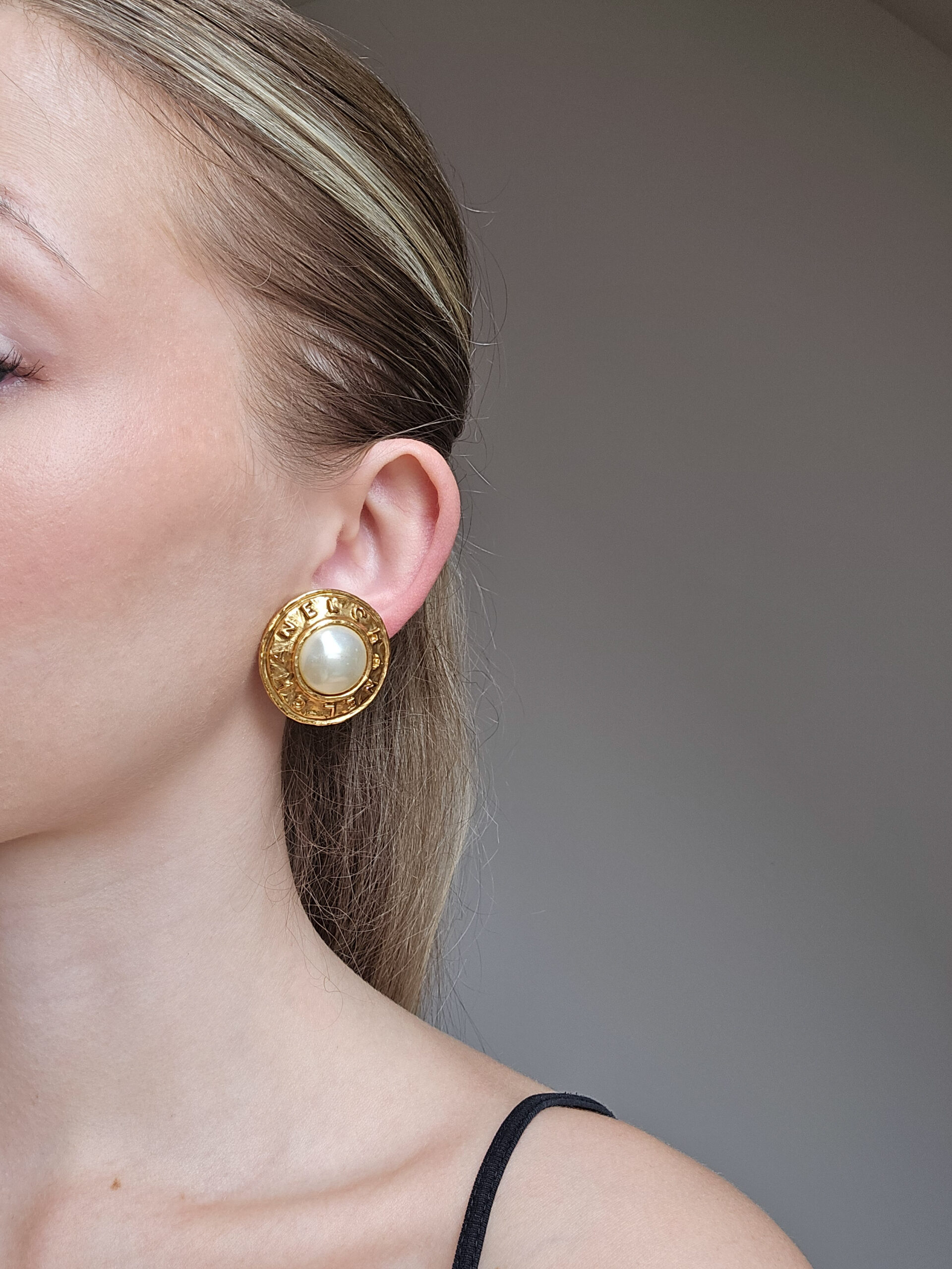 CHANEL - okrągłe klipsy vintage z perłą i wytłaczanym napisem, lata 90. na modelce