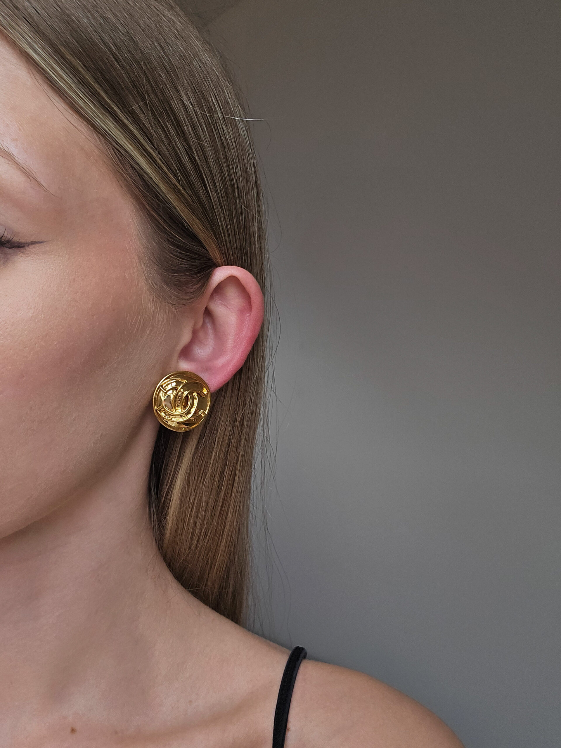 CHANEL - złote klipsy z monogramem na modelce