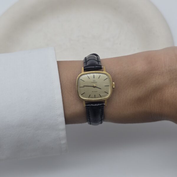 Omega De Ville - zegarek vintage na pasku z szampańską tarczą, lata 90. nadgarstek