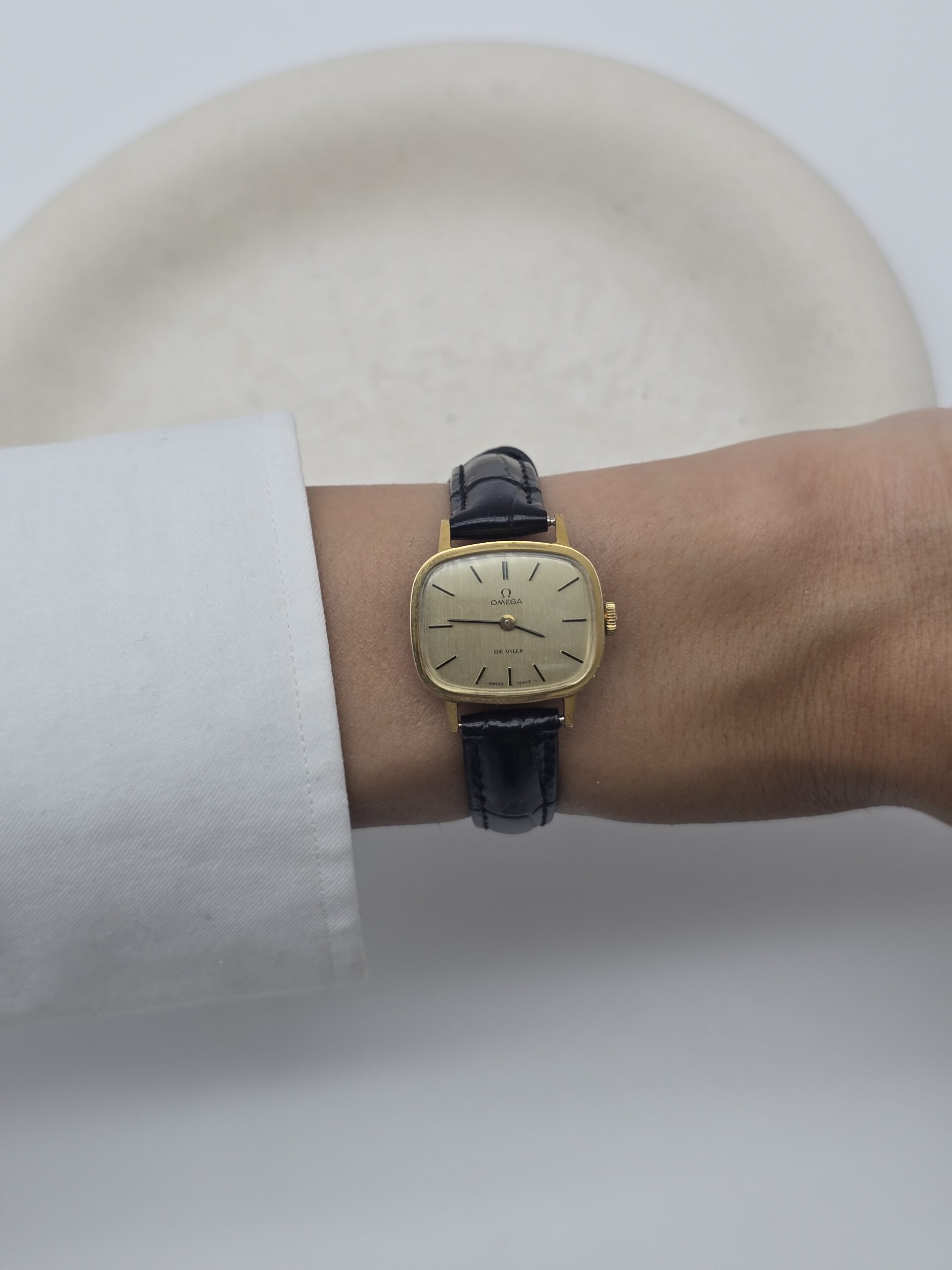 Omega De Ville - zegarek vintage na pasku z szampańską tarczą, lata 90. nadgarstek