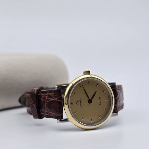 OMEGA - elegancki zegarek vintage na pasku z liniowymi indeksami, lata 80. przy podstawce