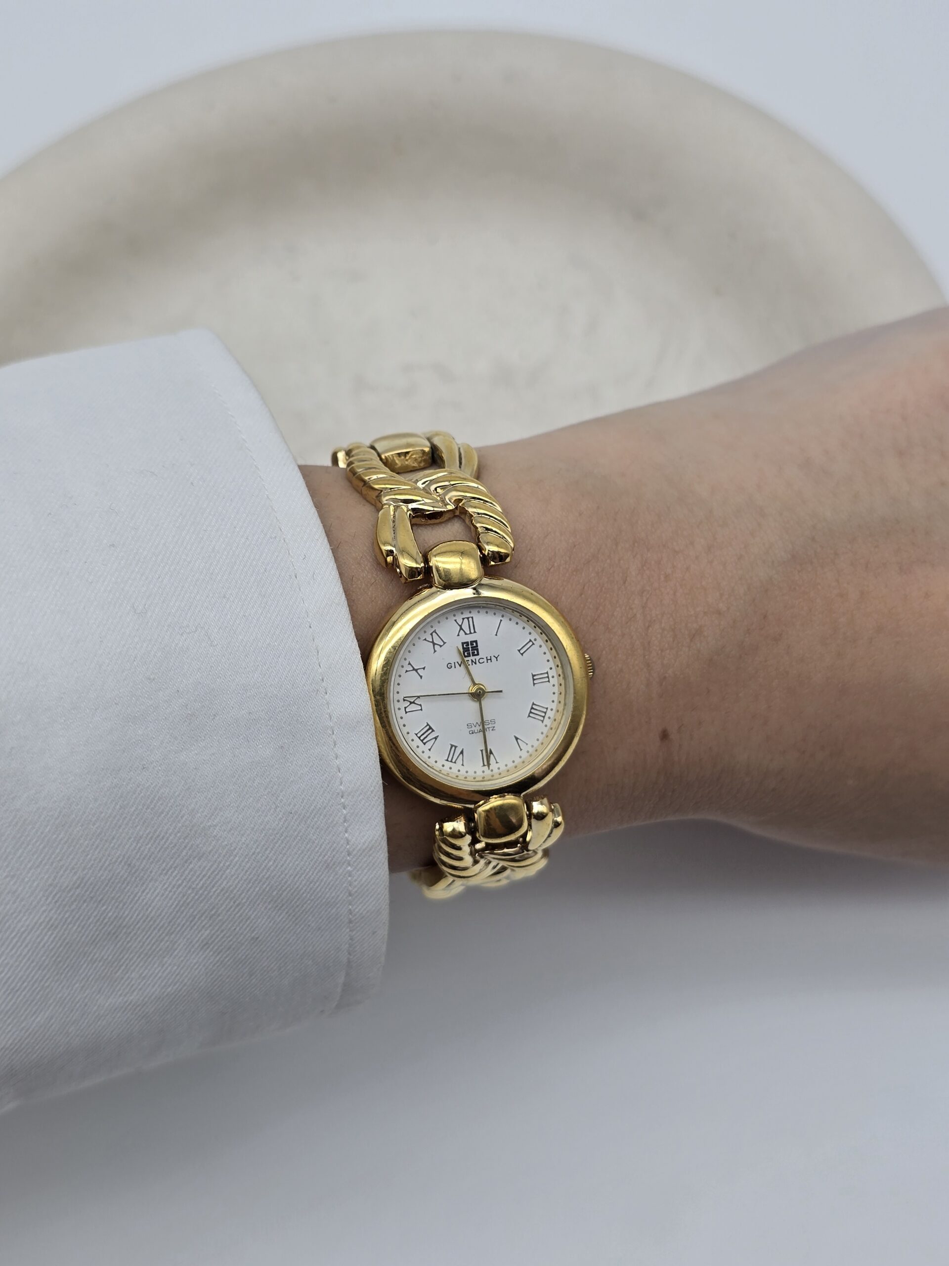GIVENCHY - klasyczny zegarek vintage z ozdobną bransoletą na sobie