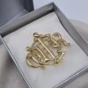 DIOR - elegancka broszka vintage z emblematem CD